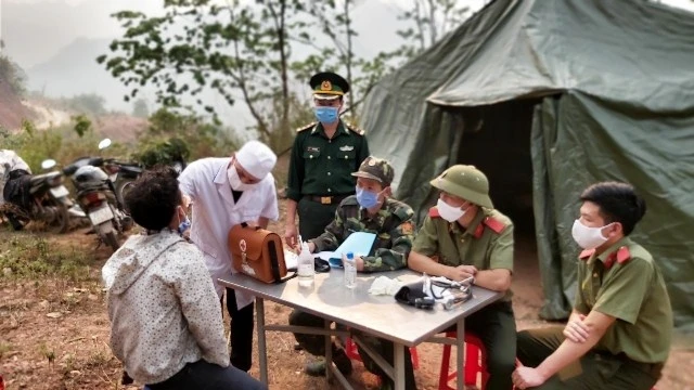 Cán bộ, chiến sĩ Đồn Biên phòng Nậm Nhừ hướng dẫn người dân biên giới cách phòng, chống dịch.