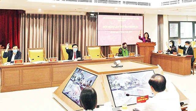 Các ủy viên Ban Chấp hành Đảng bộ thành phố Hà Nội khóa 16 biểu quyết thông qua Nghị quyết Hội nghị lần thứ 23. Ảnh: DUY LINH