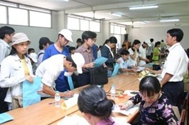 Các tân sinh viên Trường ĐH Khoa học tự nhiên đóng học phí trước khi làm thủ tục nhập học.