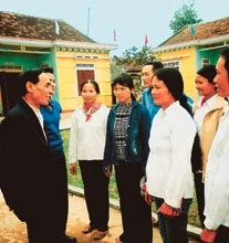 Đảng viên Trần Đình Biêng (ngoài cùng bên trái) nói chuyện truyền thống với phụ nữ địa phương.
