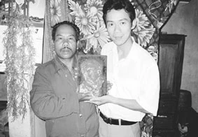 Ông Lê Xuân Rác (người bên trái) trao bức tượng Bác Hồ cho thầy giáo Phong.